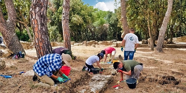 A groups of teens looking for artifacts at an archeological dig site in Tuscany.