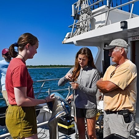 Two teen girls preparing to conduct ocean health research in Woods Hole, MA