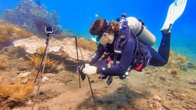 Scuba diver setting up camera as part of Restoring Coral Reefs in Bali expedition 