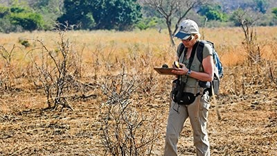 Volunteer collecing data while hiking in the field 