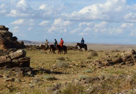 Several horsemen watch for wildlife