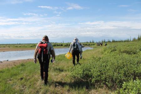 Two Earthwatch volunteers hiking through the landscape 