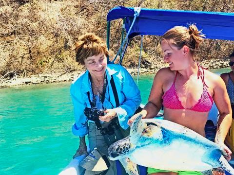 Dr. Brockway and a participant on a boat with a sea turtle.