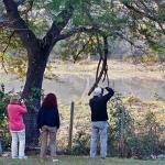 Three Earthwatch participants taking photos of scenery and wildlife in Hluhluwe-iMfolozi Park in South Africa